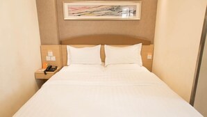 A hotel room with a bed, a nightstand, a telephone, and a framed picture on the wall. - 7 Days Inn Keyuanyi Road Shiqiao Pu (Chongqing)