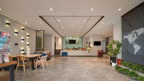 A modern hotel lobby with a reception desk, seating area, and a large world map on the wall. - 7 Days Inn Keyuanyi Road Shiqiao Pu (Chongqing)