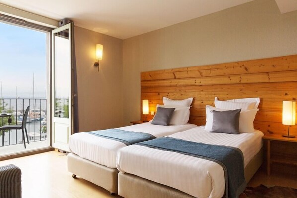 A double room with two beds, a balcony, and a city view. - Hotel the Originals Le Jules Verne (Yvoire)