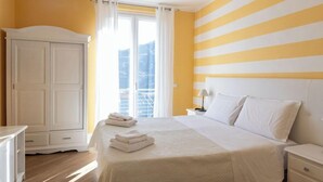 Habitación de hotel con cama, mesita de noche, armario y vistas al exterior.