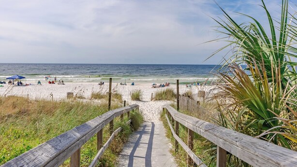 A wooden boardwalk leading to a sandy beach with people and umbrellas. - Venture Out @ Gulf Highlands Beach Resort Sleeps 6 (Panama City Beach)