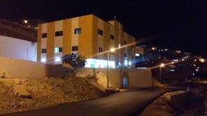 A multi-story building with a flat roof, rectangular windows, and a visible entrance with a door. - Petra Princes Hotel (Wadi Musa)