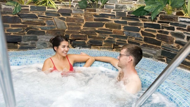 Ein Whirlpool vor einer Steinwand, mit einer Metallleiter.