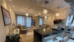 Une cuisine moderne dotée d’un îlot central, de tabourets de bar et de luminaires suspendus.