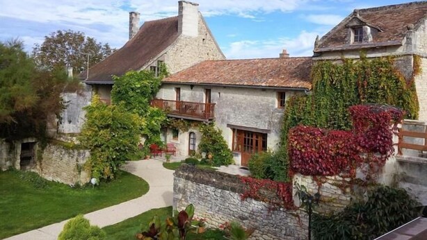 A stone building with a sloped roof, a balcony, and ivy-covered walls. - Hotel the Originals Pigeonnier Du Perron (Availles-en-Chatellerault)