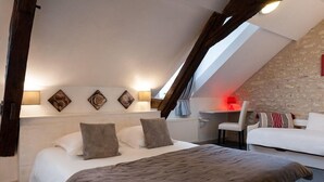 A bedroom with a large bed, a desk, and a chair. There are wall-mounted lamps and artwork above the bed. - Hotel the Originals Pigeonnier Du Perron (Availles-en-Chatellerault)