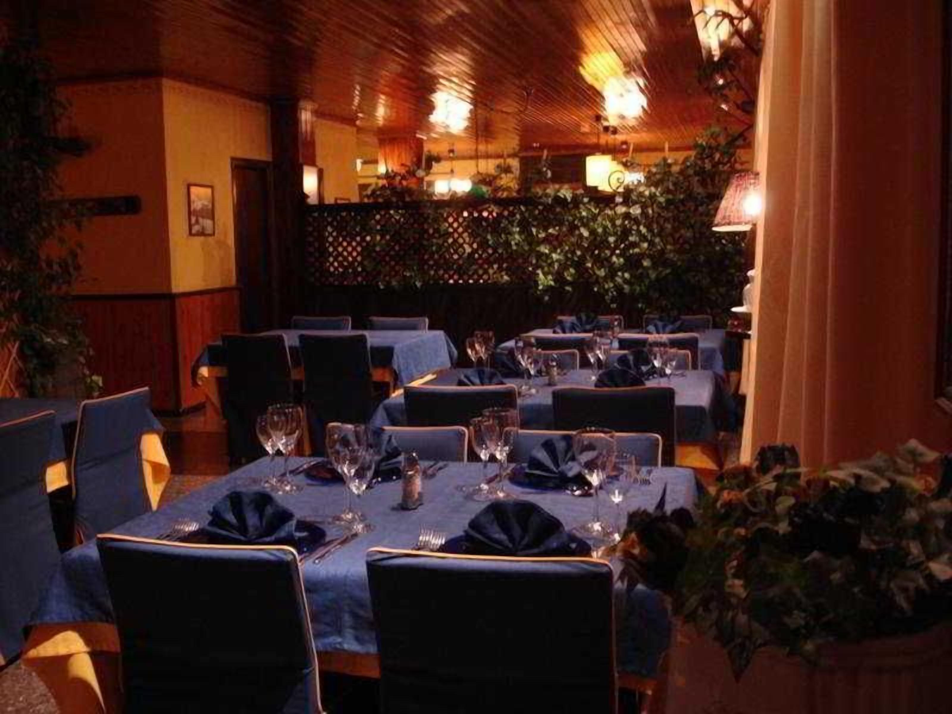 A restaurant with tables set for dining, chairs, and a warm ambiance.