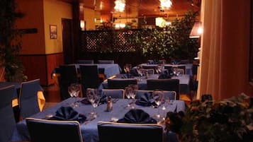 A restaurant with tables set for dining, chairs, and a warm ambiance.