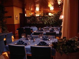 A restaurant with tables set for dining, chairs, and a warm ambiance.