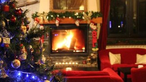 A cozy living room with a fireplace, a Christmas tree, and red furniture. - Peretol (Bordes d'Envalira)