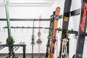 A ski storage rack with multiple skis and ski boots. - Serrano (Vielha e Mijaran)