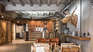 A reception area with wooden furniture, a large animal skull on the wall, and a counter with informational displays. - Serrano (Vielha e Mijaran)