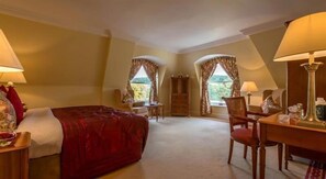 A hotel room with a bed, a desk, two chairs, a dresser, and two windows with curtains. - Glen View Hotel (Delgany)