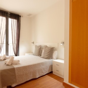 A bedroom with a bed, bedside tables, and a window with curtains. - Apartamentos El Carmen by Be Alicante (Alicante)
