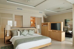 Una habitación de hotel moderna con una cama grande, un televisor, un armario de madera y un espejo.