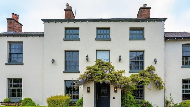 A two-story building with a symmetrical facade, multiple windows, and a central entrance with a door. - The Vicarage (Crewe)