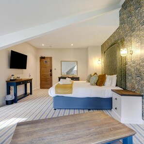 A bedroom with a bed, bedside tables, a desk, a TV, and a patterned wall. - Thatchers BW Signature Collection BY Best Western (Leatherhead)