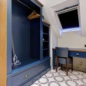 A room with a desk, chair, and a built-in wardrobe with shelves and a hanging rack. - Thatchers BW Signature Collection BY Best Western (Leatherhead)