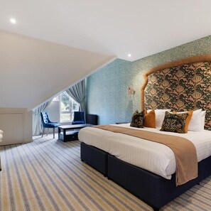 A bedroom with a large bed, a desk, and a chair. - Thatchers BW Signature Collection BY Best Western (Leatherhead)