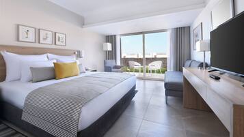 Quarto de hotel moderno com uma cama grande, uma escrivaninha, televisão e varanda com vista.