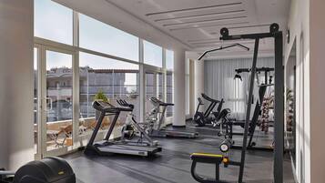 A modern gym with cardio machines, free weights, and a mirror.