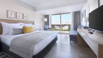 A modern hotel room with a large bed, a desk, a flat-screen TV, and a balcony with a view.