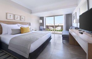 Une chambre d’hôtel moderne dotée d’un grand lit, d’un bureau, d’une télévision et d’un balcon avec vue.