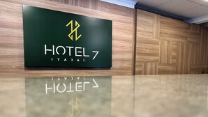 Un letrero de hotel con logotipo y nombre, colocado en una pared con paneles de madera.