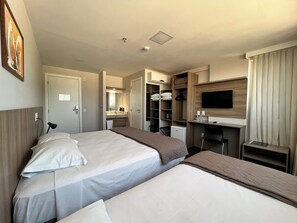 A hotel room with two beds, a TV, a desk, and a wardrobe. - Hotel 7 Itajai (Itajai)