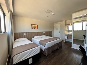 Une chambre d’hôtel avec deux lits, une salle de bain et une vue sur la ville.