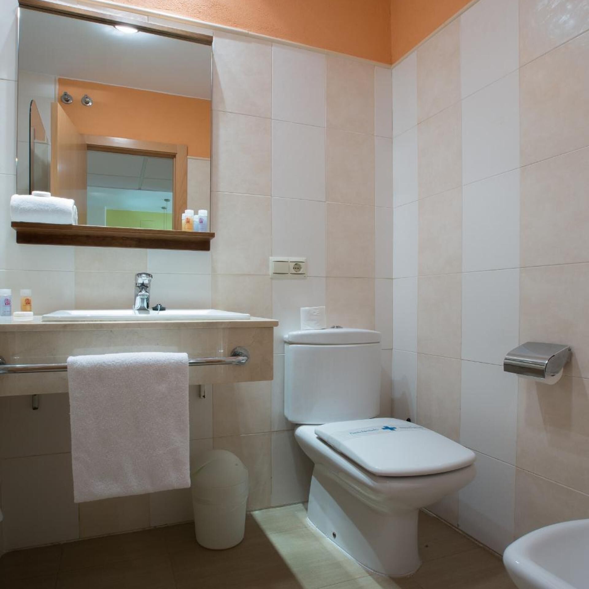A bathroom with a sink, toilet, and bidet.