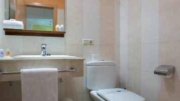 A bathroom with a sink, toilet, and bidet.