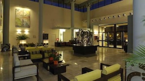 Un'ampia hall con soffitto alto, una fontana decorativa al centro e zone relax.