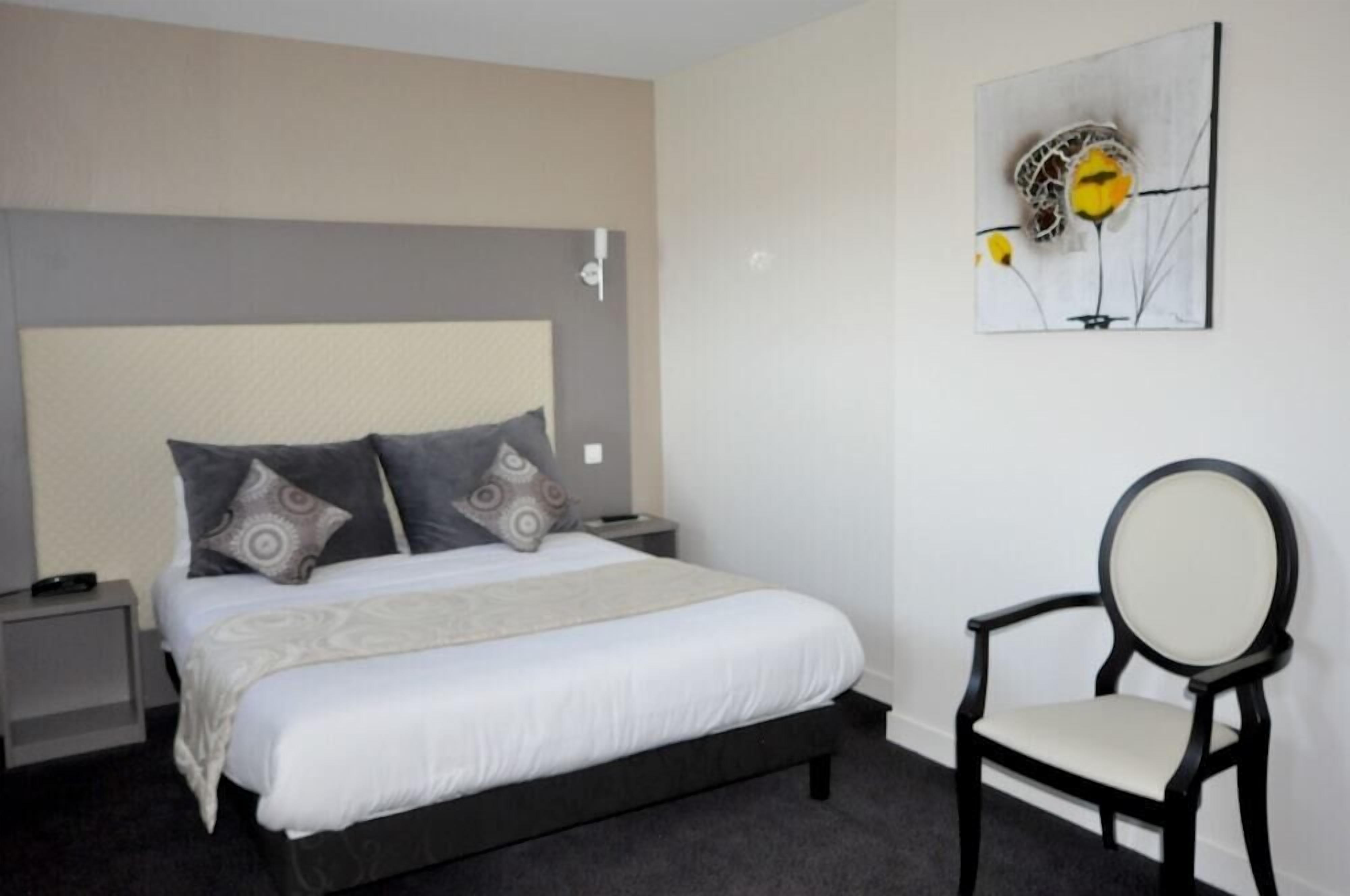 A neatly arranged bedroom with a bed, nightstands, a chair, and a wall-mounted artwork.