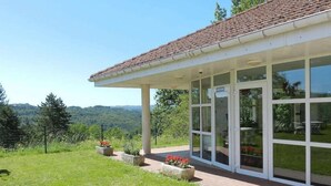 Un edificio moderno con ampie vetrate e una veranda coperta.