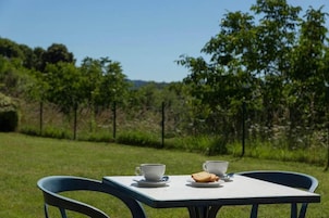 Mesa com duas xícaras e duas fatias de pão em um jardim.