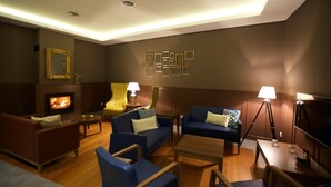 A modern living room with a fireplace, comfortable seating, and ambient lighting. - Charming Blue (Vila do Porto)