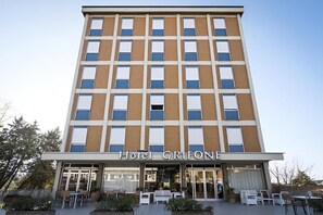 Un hotel con fachada moderna, varias ventanas y un cartel que dice 'Hotel Grifone'.