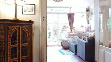 A room with a large cabinet, a sofa, and a view of the outside.