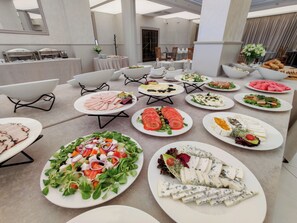 A buffet with various food options including salads, meats, and cheeses. - Queens Apartments (Kraków)