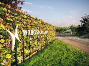 Une enseigne pour le WYBOSTON RESORT, avec un mur composé de différentes plantes.