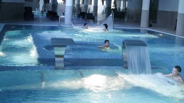 A large indoor swimming pool with multiple lanes and a central water slide. - Monte Rio (Sao Pedro do Sul)