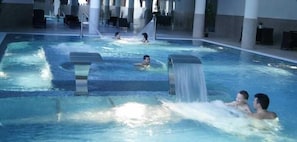 A large indoor swimming pool with multiple lanes and a central water slide. - Monte Rio (Sao Pedro do Sul)