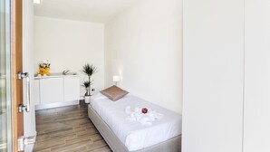 A small, clean room with a bed, a bedside table, a lamp, and a plant. - The Florence Hills Resort Spa (Pelago)