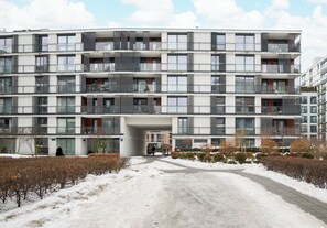 A multi-story residential building with balconies, a covered entrance, and a snow-covered pathway. - Business Mokotów Park 23 Studio (Warszawa)