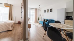Un salon moderne comprenant un canapé, une table à manger et un coin cuisine.