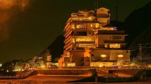 A multi-story hotel with balconies and a waterfront view. - Shukukaifu (Minamichita)