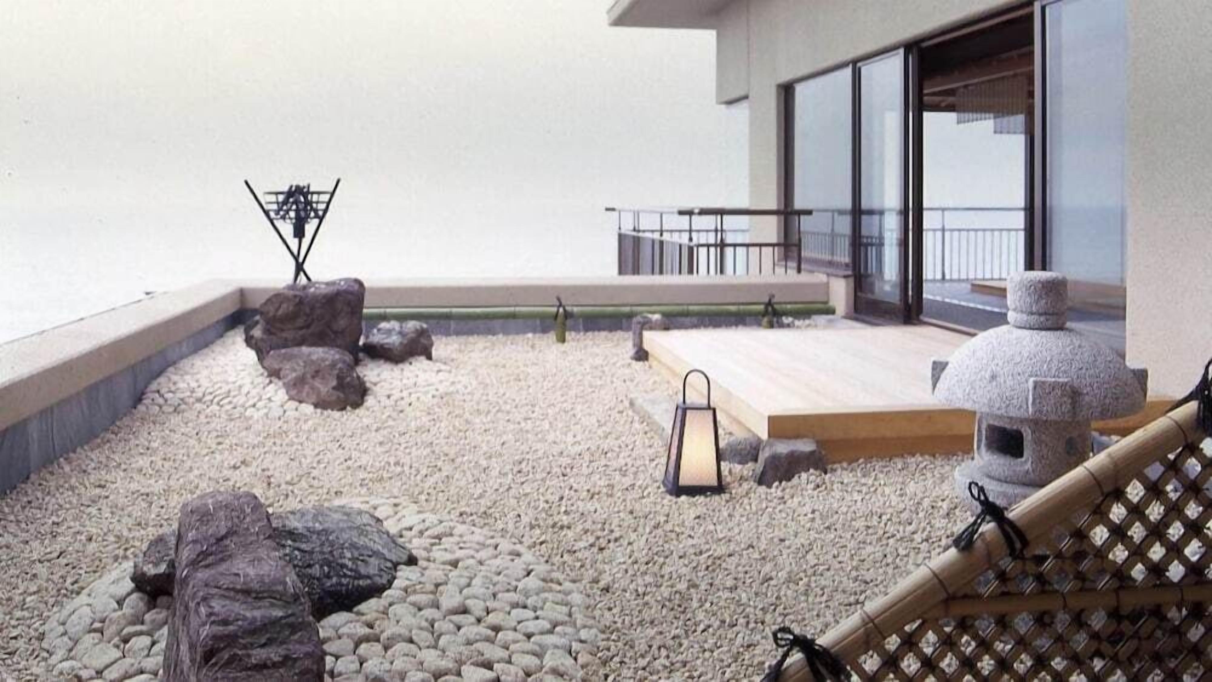 Un jardin sur le toit, doté d’une terrasse en bois, d’un espace salon et d’une lanterne en pierre.