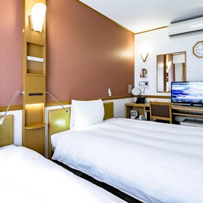 A hotel room with a bed, bedside tables, a desk with a computer, a mirror, and a clock on the wall. - Toyoko Inn Takasakieki Nishiguchi No 2 (Takasaki)