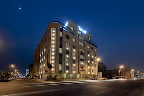 A multi-story hotel with illuminated windows and a prominent sign.
